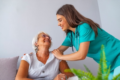 female nurse and senior woman smiling