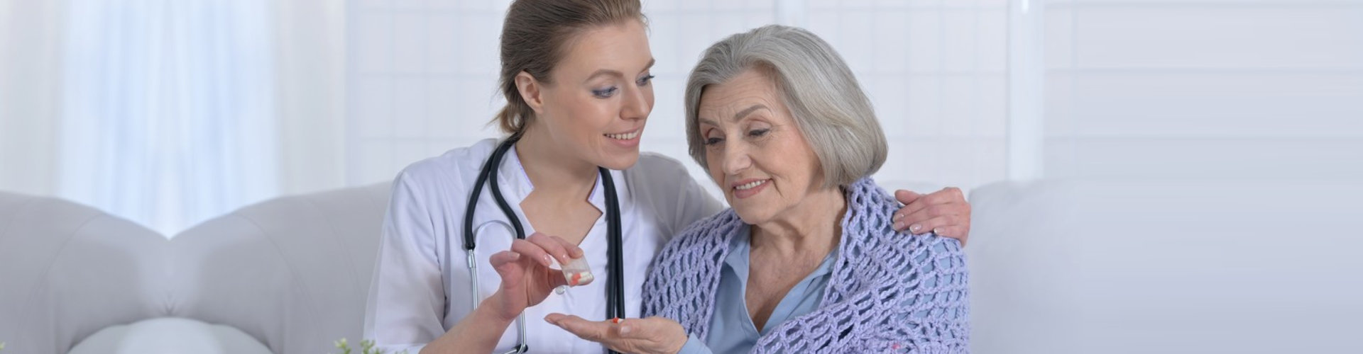 nurse giving medicine to senior woman